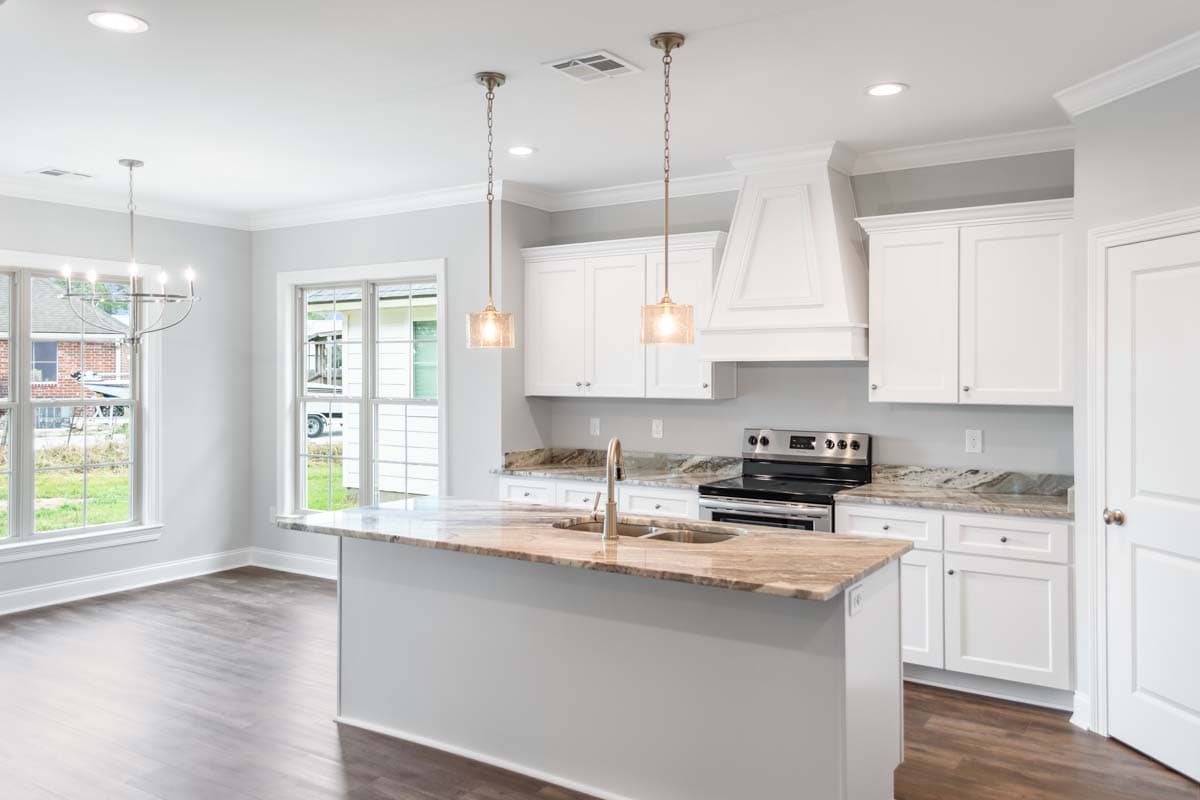 Kitchen with island, white cabinets, granite countertops, stainless steel range, and pendant lighting.