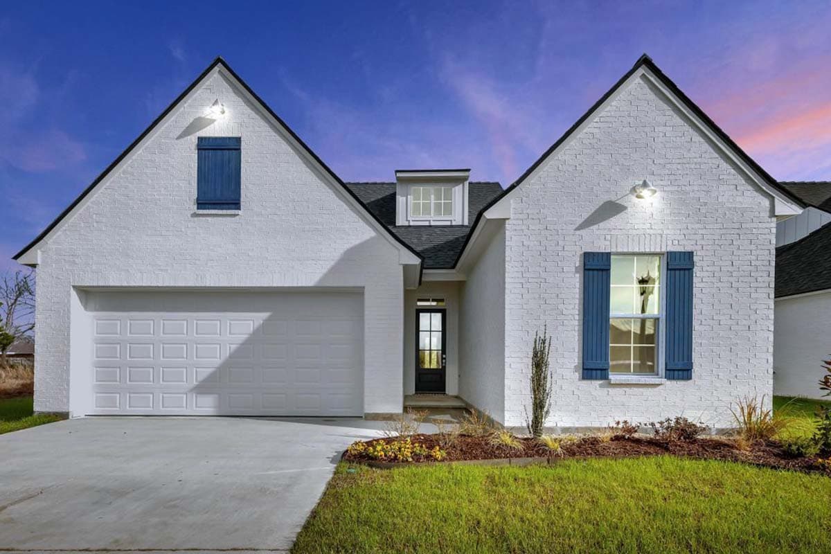 House plan exterior: White brick one-story home with a two-car garage, pitched gable roofs, a dormer, and blue shutters.