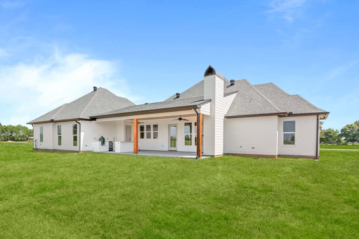 House plan exterior: Ranch-style, single-story with a covered patio, outdoor kitchen, and prominent chimney.