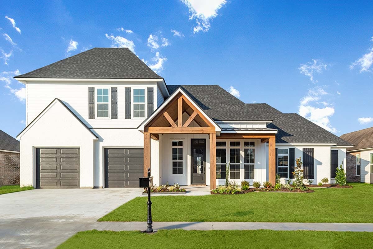House plan exterior. Two-story Modern Farmhouse with a gabled roof, a front porch with exposed beams, and a two-car garage.