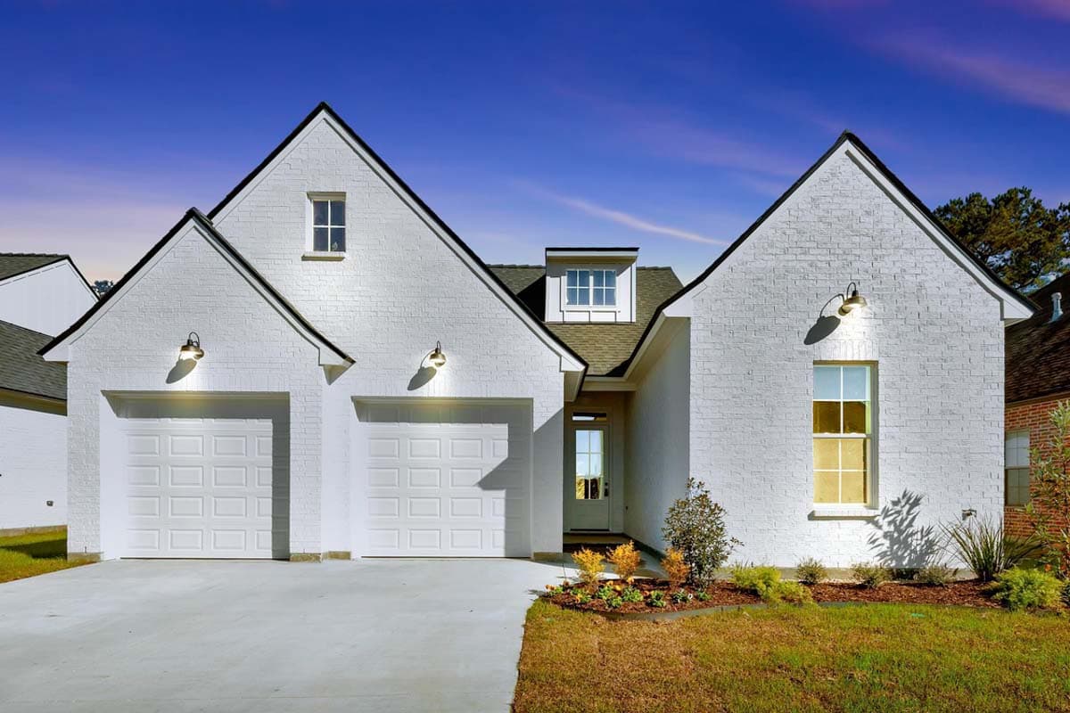 House plan exterior. Two-story, brick facade, farmhouse style. Features include gabled roof, dormers, and two-car garage.