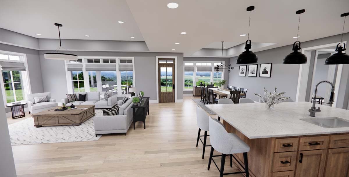 Open-concept living area with large windows, dining room, and kitchen island with seating. House plan interior.