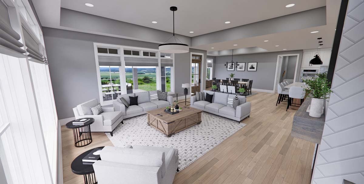 Open concept living area with sectional sofas, wood coffee table, dining area, and kitchen island.