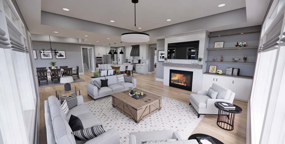Modern open concept living room with fireplace, kitchen island, dining area, and vaulted ceiling.
