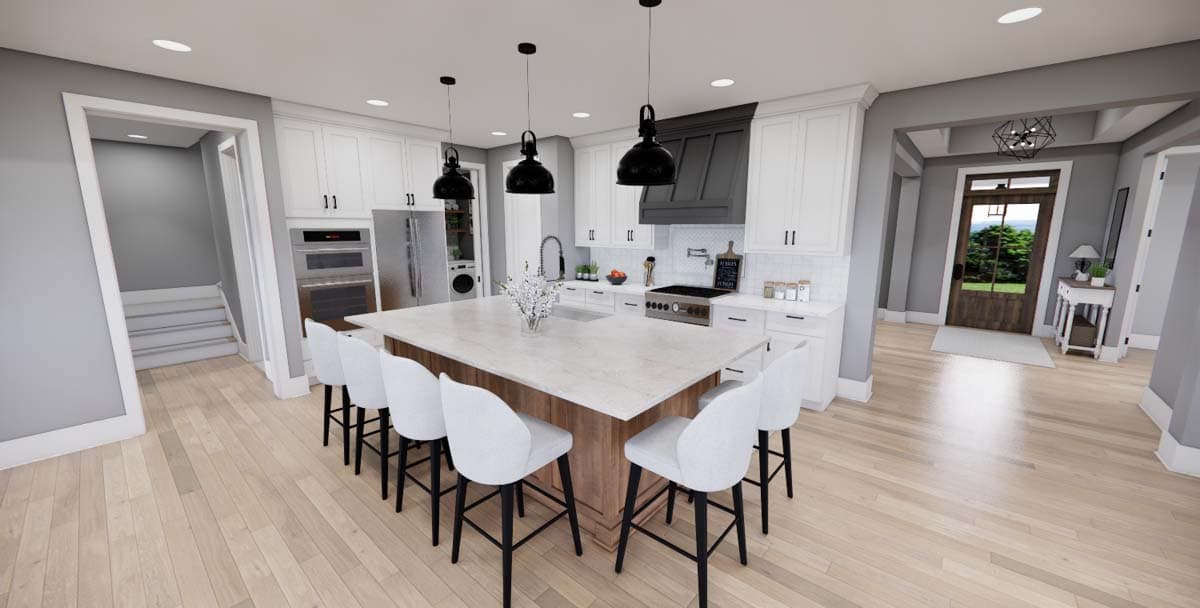 Kitchen with large island, white cabinets, stainless steel appliances, and entryway visible.