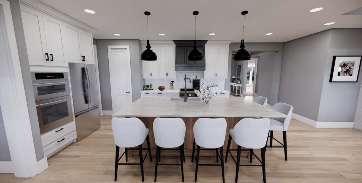 Kitchen with white cabinets, large island with seating, stainless steel appliances, and pendant lights.