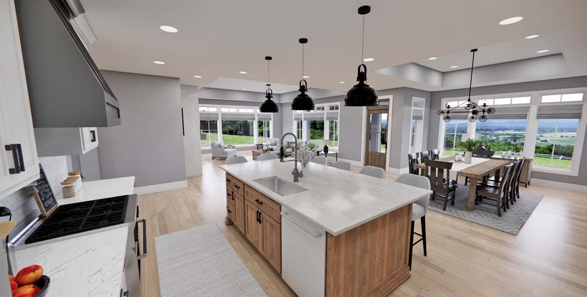 Open-plan kitchen and dining area with large island, island pendant lights, dining table, and scenic window views.