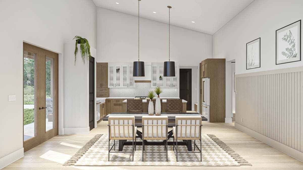 Open concept dining area and kitchen with vaulted ceiling, pendant lights, and wood cabinetry.