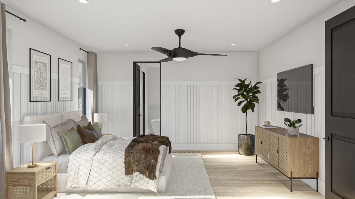 Primary bedroom with a bed, ceiling fan, television, and an open doorway to a bathroom.