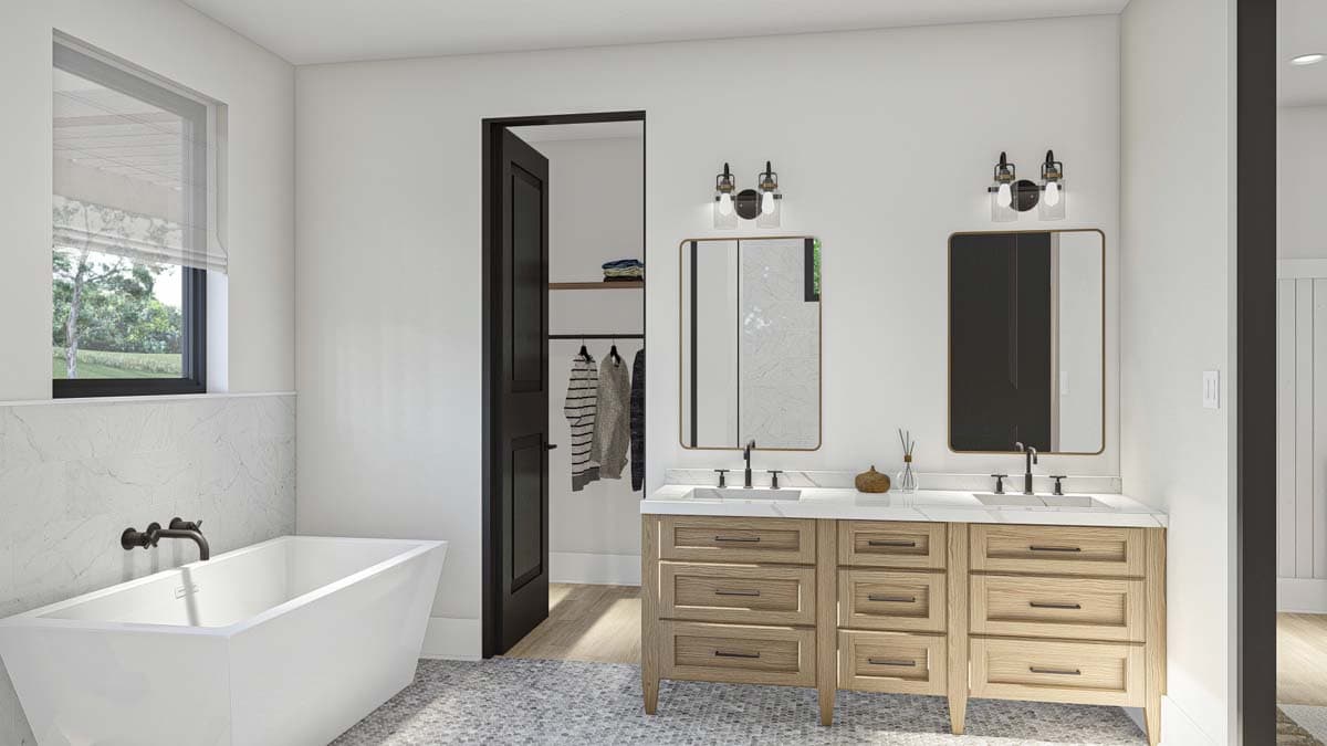 Modern bathroom with freestanding tub, double vanity with wood drawers, and walk-in closet access.
