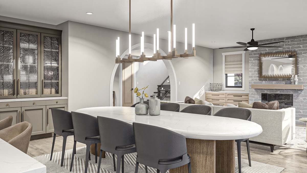 Rendering of open-concept dining and living area featuring an oval dining table, sectional sofa, fireplace, and built-in cabinetry.