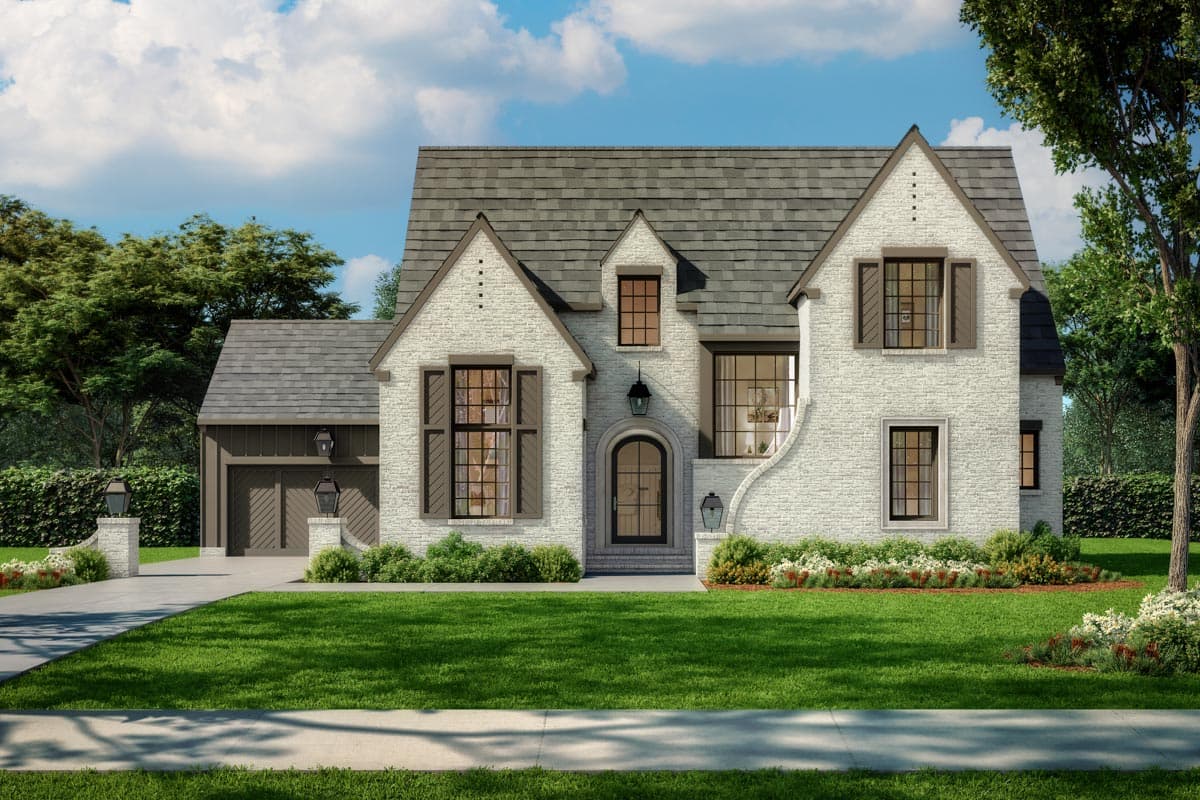 House plan exterior. Two-story Tudor style house with gabled roof, brick facade, arched entry, and detached garage. Features dormers and shutters.