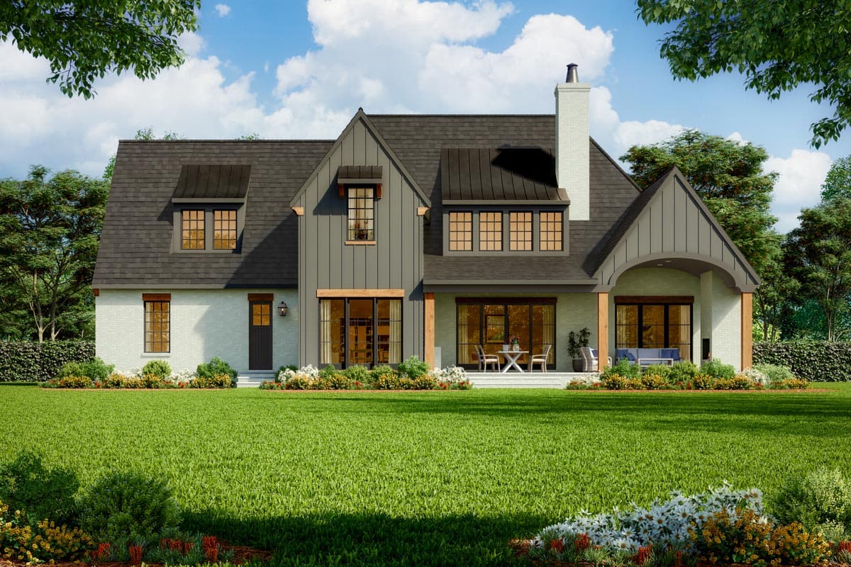 Modern Farmhouse house plan exterior with white brick, dark gable accents, metal roof dormers, and a covered patio.