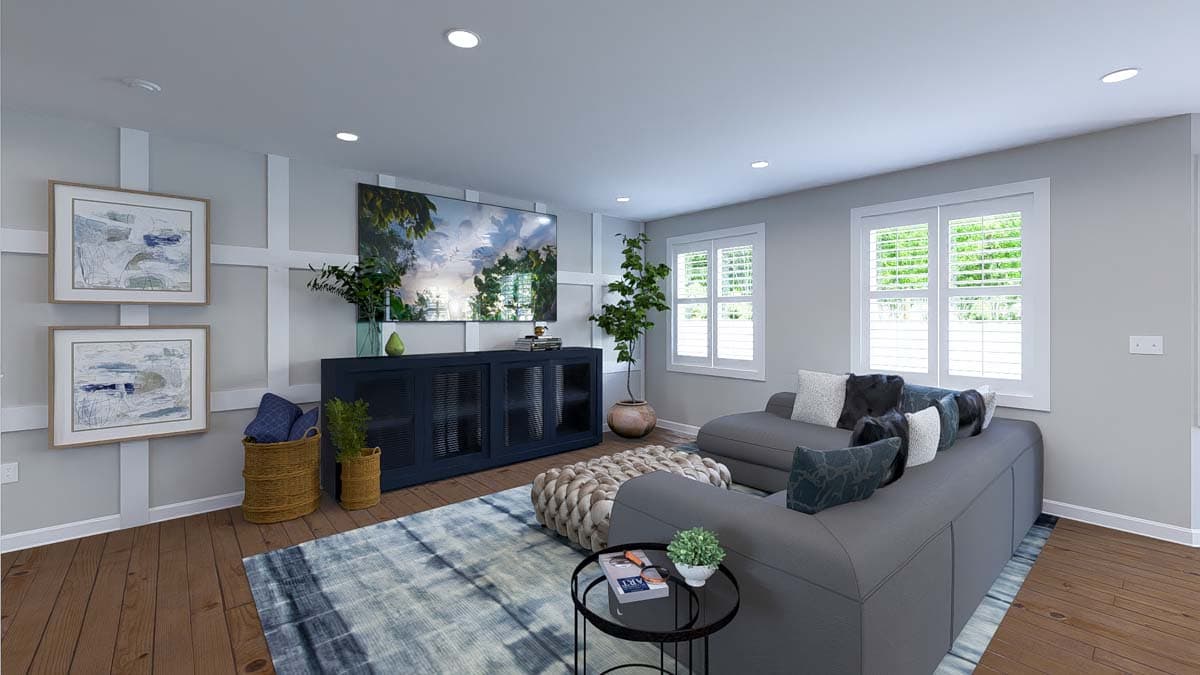 Living room with gray sectional sofa, dark blue media console, two framed artworks, and large windows with shutters.