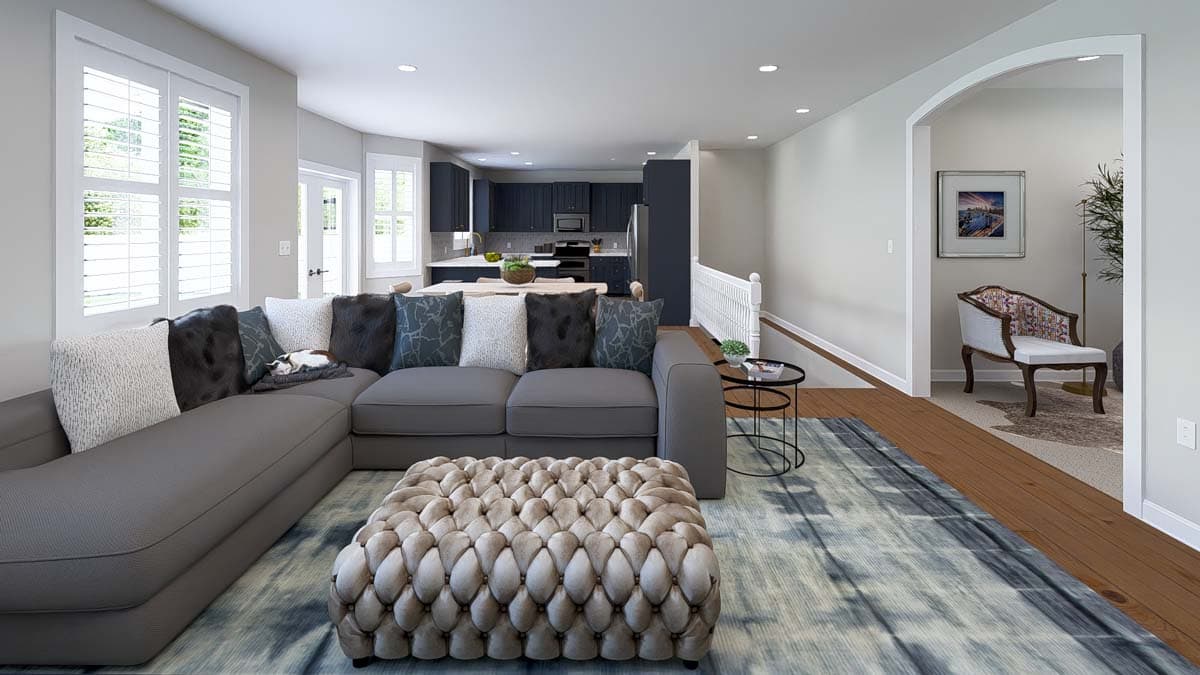 Interior rendering of open concept living area with sectional sofa, kitchen, dining area, and staircase.
