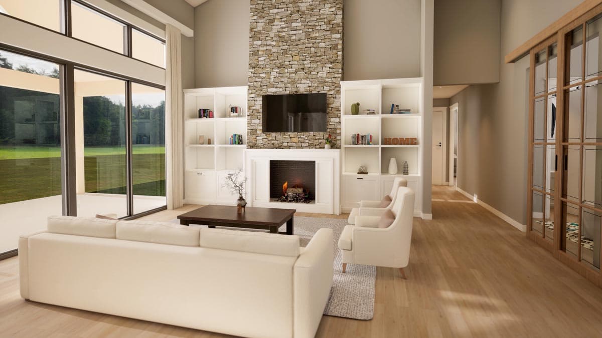 Great room with vaulted ceiling, stone fireplace, built-in shelving, and large windows.