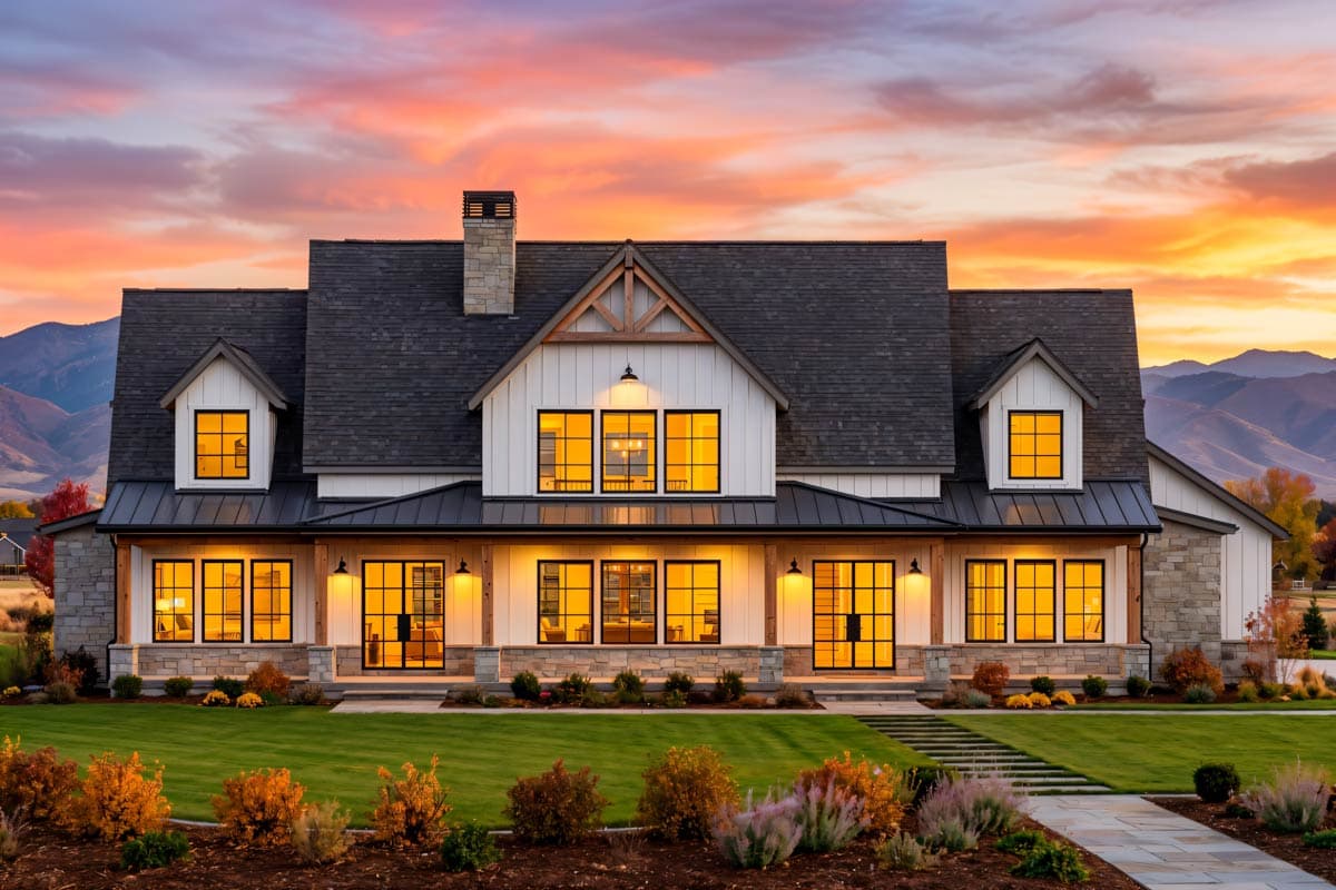 Modern Farmhouse house plan exterior with wraparound porch, stone accents, gable dormers, and prominent chimney.
