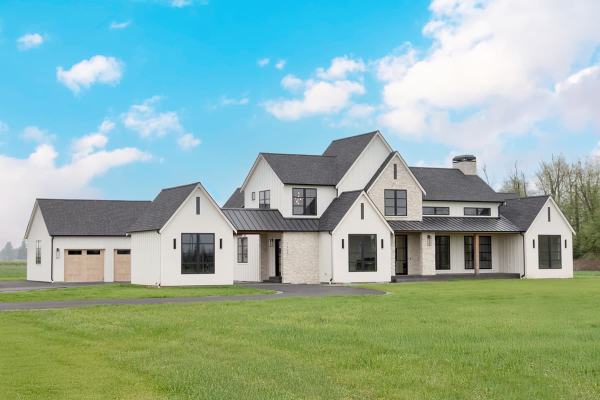 Modern Farmhouse house plan exterior with white board-and-batten siding, stone accents, black-framed windows, gables, and attached garage.
