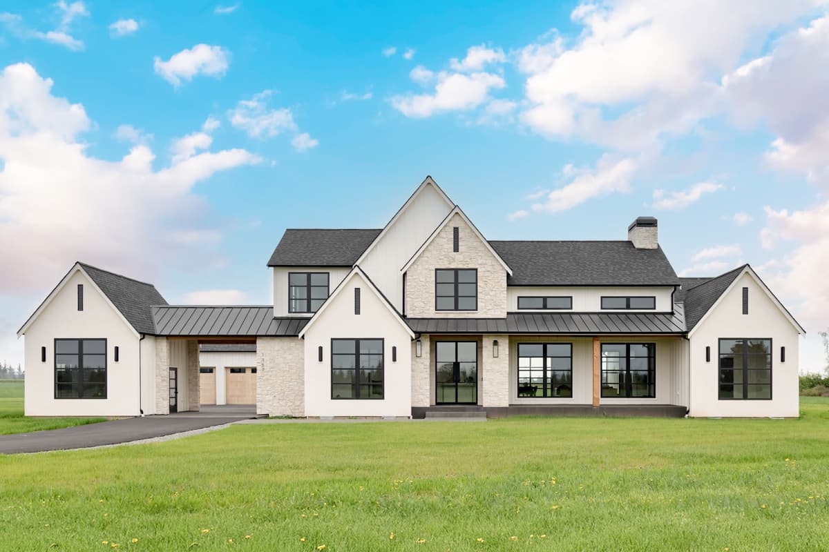 Modern Farmhouse exterior with gabled roof, stone accents, and covered porch. Two-story house plan with detached garage and black-framed windows.