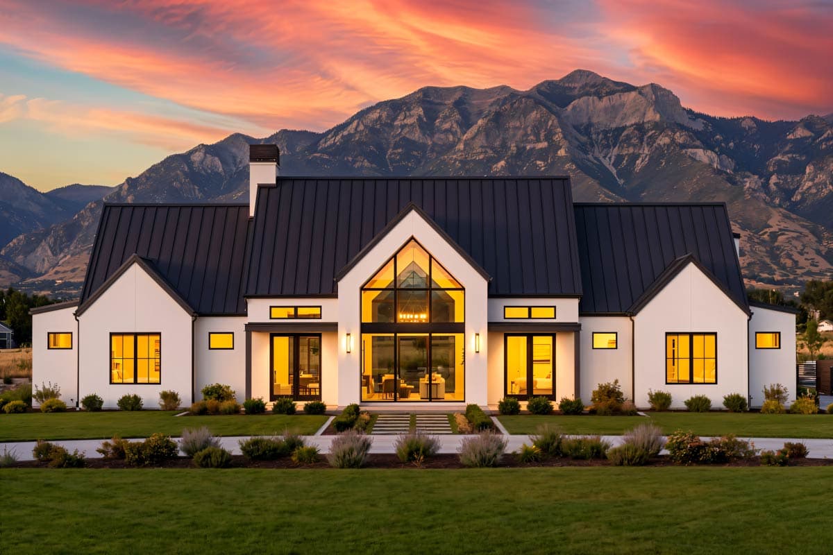 Modern Farmhouse house plan exterior with black metal roof, prominent gables, and expansive glass entryway.