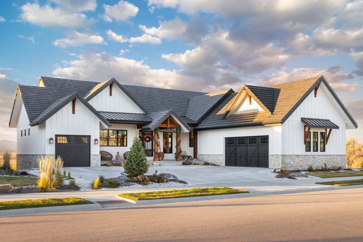 House plan exterior. Modern Farmhouse style, one-story. Features include gabled rooflines, stone accents, and a covered entry porch.