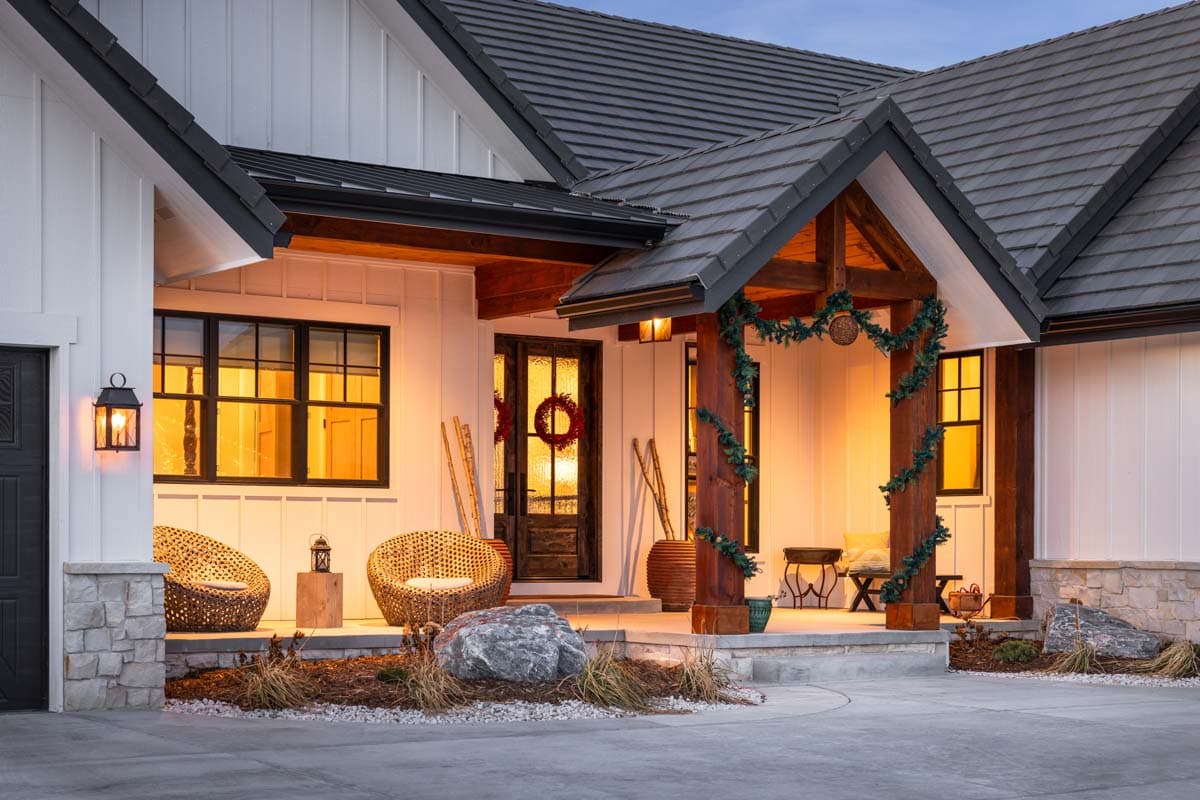 Modern Farmhouse house plan exterior with board and batten siding, stone accents, prominent gables, and a covered timber-framed porch.