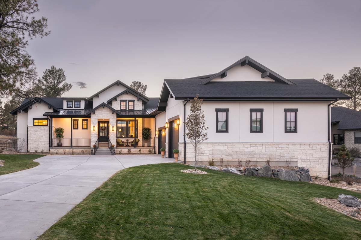 Modern Farmhouse house plan exterior with white stucco, stone accents, dark gables, dormers, and a covered porch.