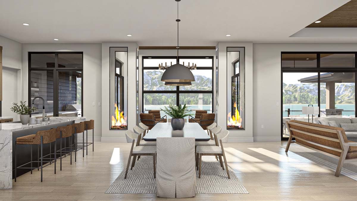 Spacious, modern dining room with a long table, chairs, and a large window overlooking a scenic mountain view. Fireplaces flank the central window.
