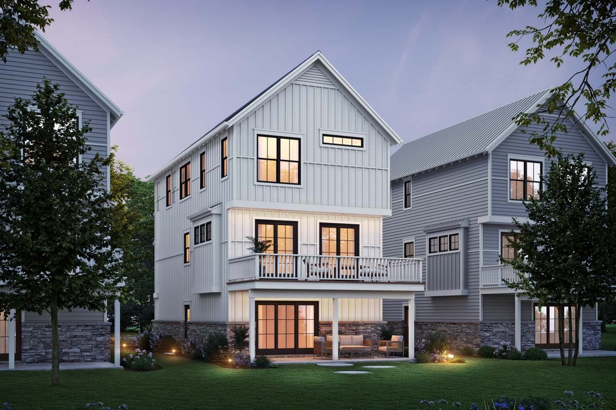 Modern Farmhouse style house plan exterior, three stories, white vertical siding, deck, stone base, gabled roof.