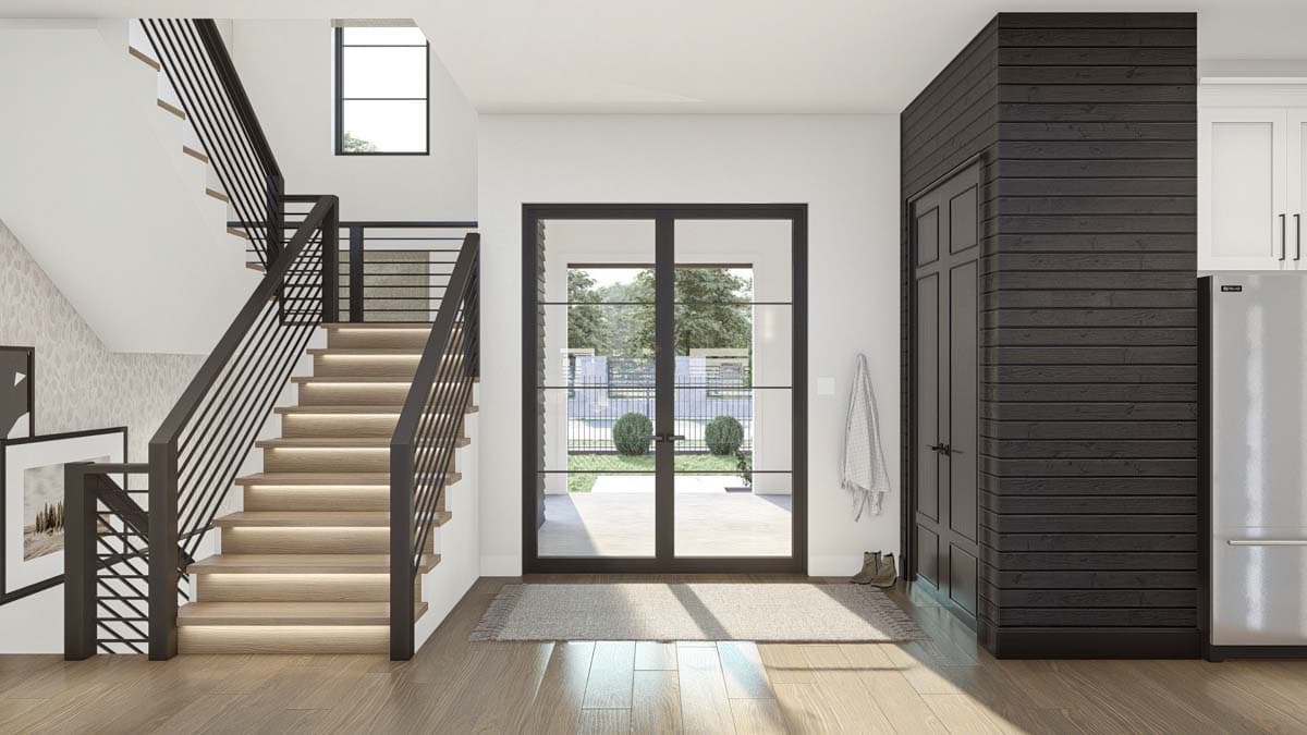 Modern interior view with contemporary staircase, double glass doors to exterior, and dark wood paneled wall with cabinetry.