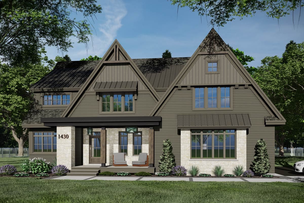 A craftsman-style house with a stone and wood exterior sits on a green lawn. The house has a steeply pitched roof and multiple gables.