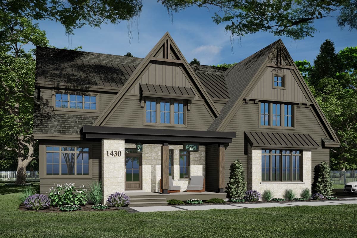 A modern two-story house with a dark gray exterior, stone accents, and a covered porch. Landscaping includes bushes and trees, with a view of a blue sky.