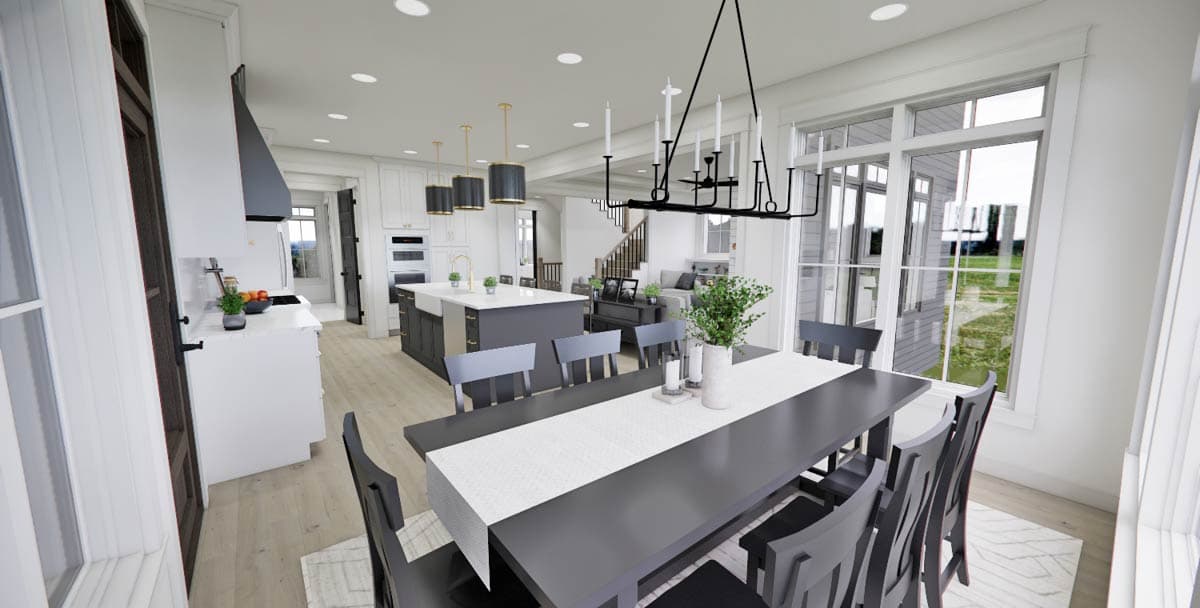 Spacious, modern kitchen and dining room with gray and white color scheme. A large dining table sits in the foreground with a chandelier overhead.