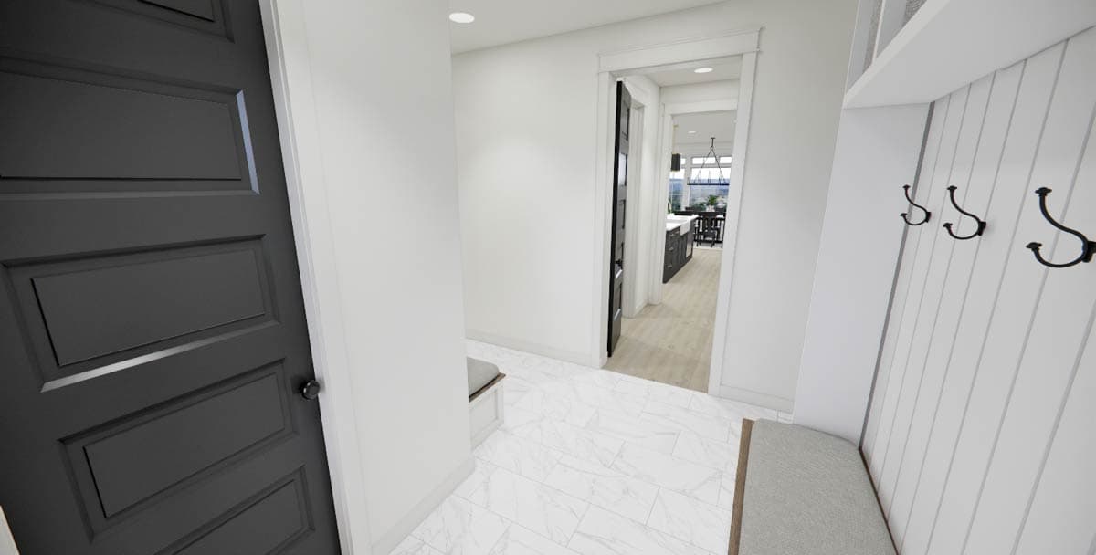 An entryway hallway with a black door on the left, white walls, and a view through to a kitchen. A bench and hooks are on the right.