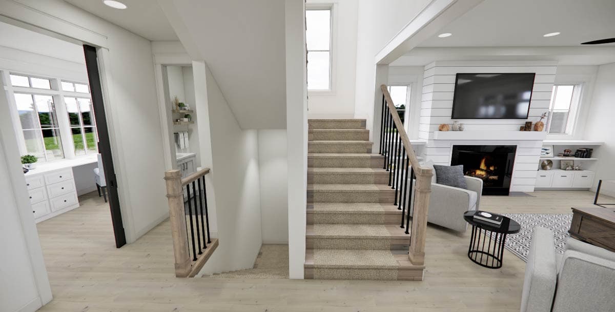 A modern, bright interior featuring a staircase with carpeted steps, a fireplace with a mounted TV, and an adjacent living area.