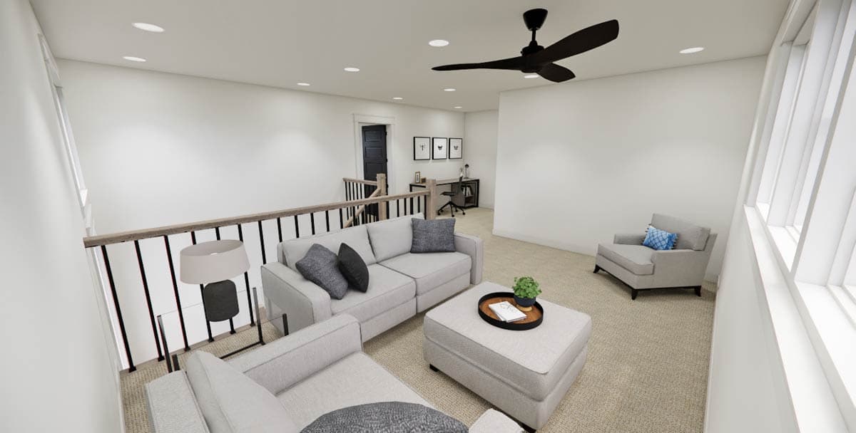 A modern loft living space with a sofa, chair, and ottoman. A desk is visible behind the seating area, with a black ceiling fan overhead.