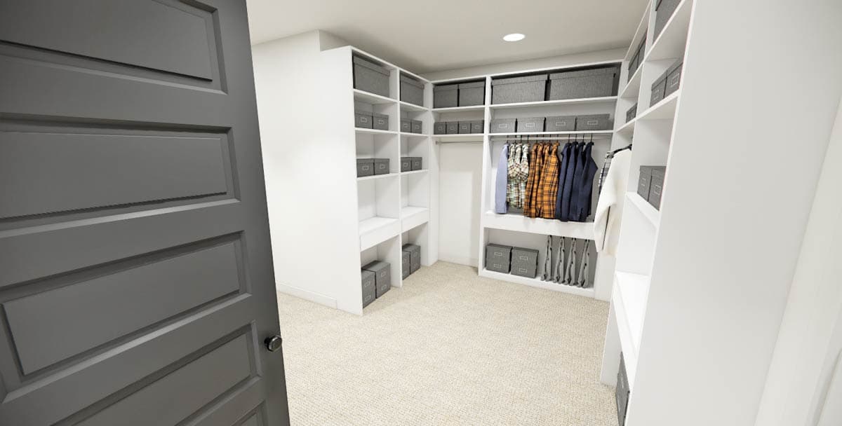A walk-in closet with white shelving, gray storage boxes, and clothing hanging on rods. A partially visible, dark gray door is in the foreground.