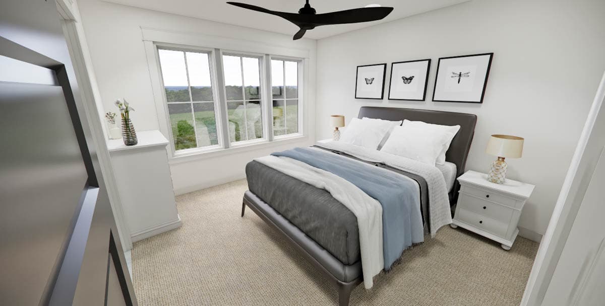 Modern bedroom with a bed, nightstand, and framed art. Large windows look out to a green landscape, and a dark ceiling fan hangs above.