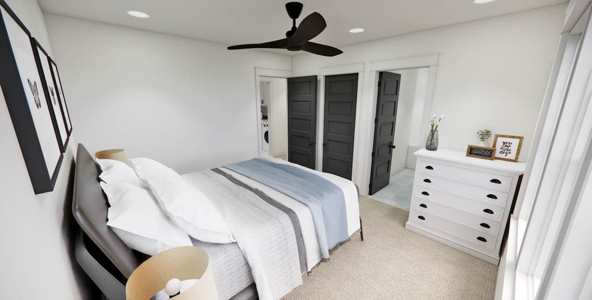 A modern bedroom features a bed with a blue and white blanket, black doors, and a white dresser with decor, illuminated by recessed lights.
