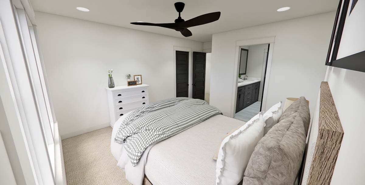 A modern bedroom with a bed covered by a grey and white patterned blanket. There's a white dresser, a ceiling fan, and a bathroom doorway.