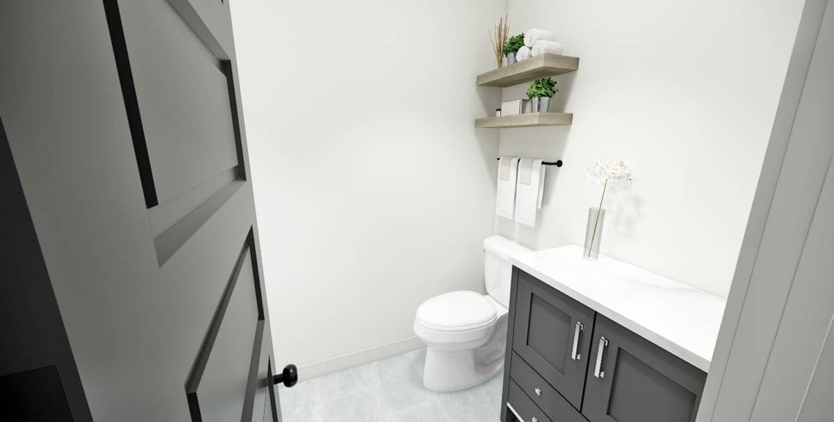 A modern bathroom interior. A dark gray vanity, toilet, and white walls create a simple design. Open shelves hold towels and plants.