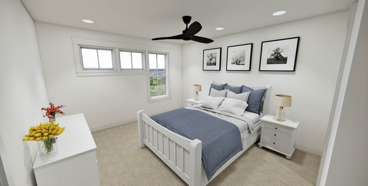 A bedroom with white walls, a white bed frame with blue bedding, and a black ceiling fan. Three framed pictures hang above the bed.