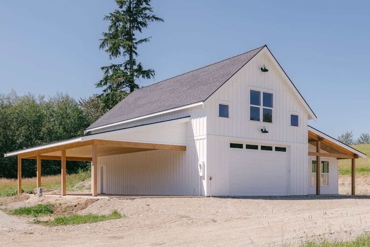 Modern Farmhouse style house plan exterior with white board and batten siding, attached carport, and gable roof.