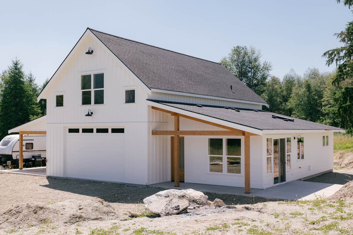 Modern Farmhouse house plan exterior with two stories, white vertical siding, gable roof, attached garage, and covered porch.