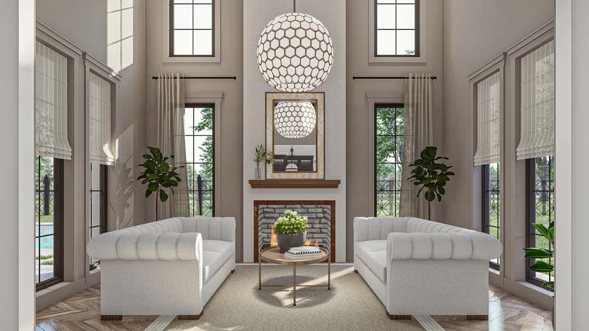 Vaulted great room with fireplace, two sofas, large windows, and a decorative light fixture.