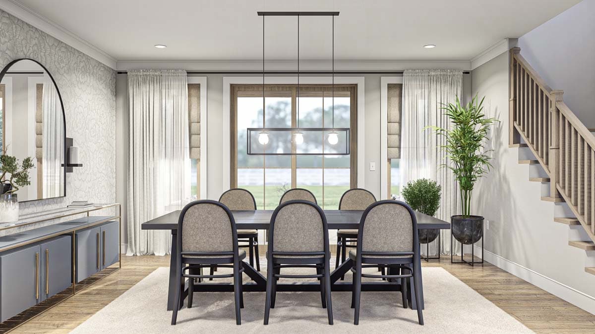 Dining room with table, chairs, sideboard, arched mirror, patterned wallpaper, large window, and staircase.