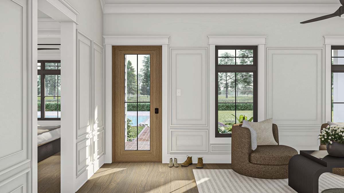 Interior view of a house plan showing a living room with a wooden door, windows overlooking a yard, and wainscoting.