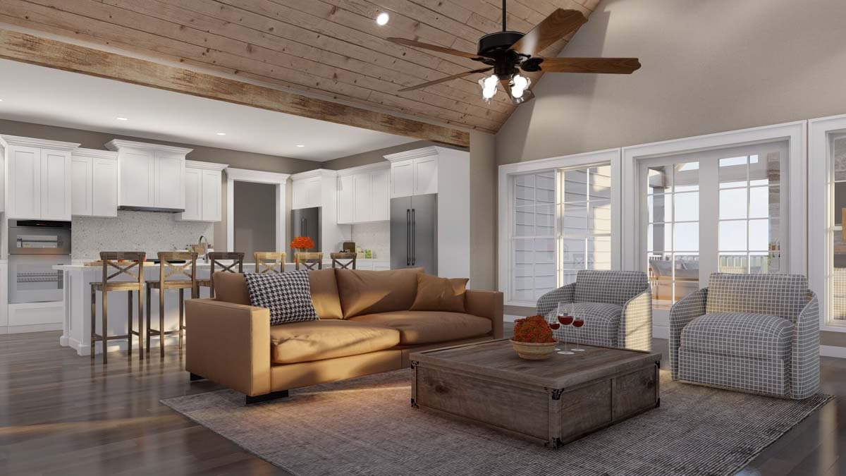 Open concept living area with vaulted beamed ceiling, kitchen island with bar stools, and large windows.