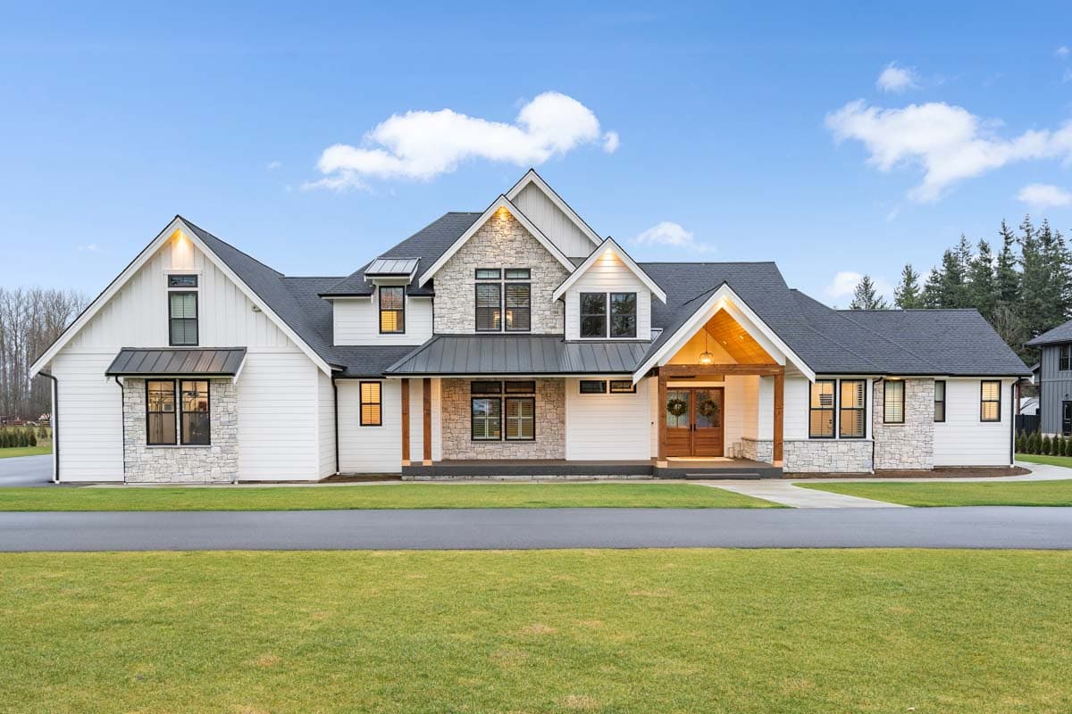 House plan exterior. Modern farmhouse style with stone accents, covered porch, multiple gables, and dark gray roof. Two stories.