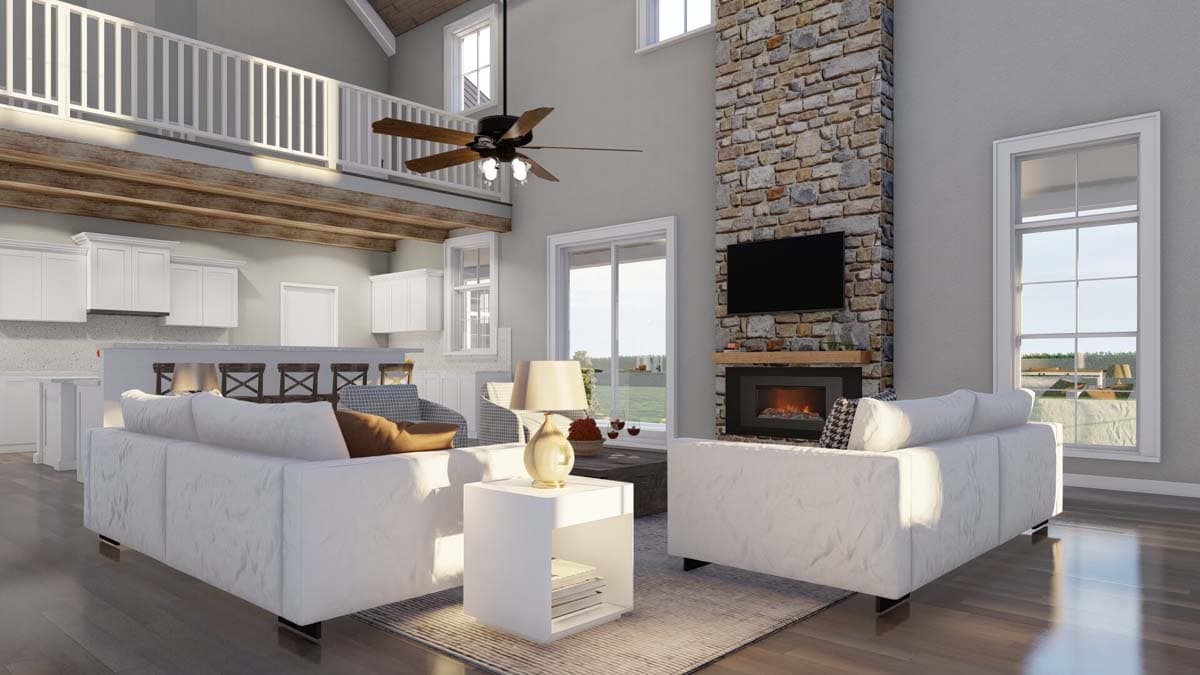 Open concept living area with vaulted ceiling, exposed beams, stone fireplace, kitchen island with seating, and loft.